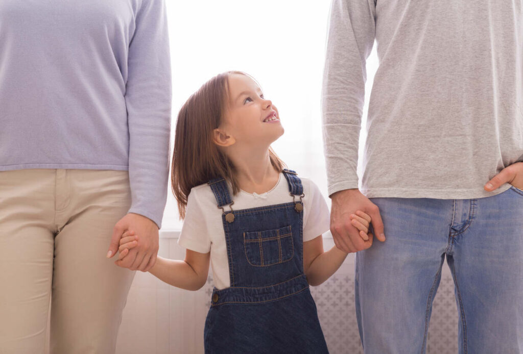 child holding hands of parents